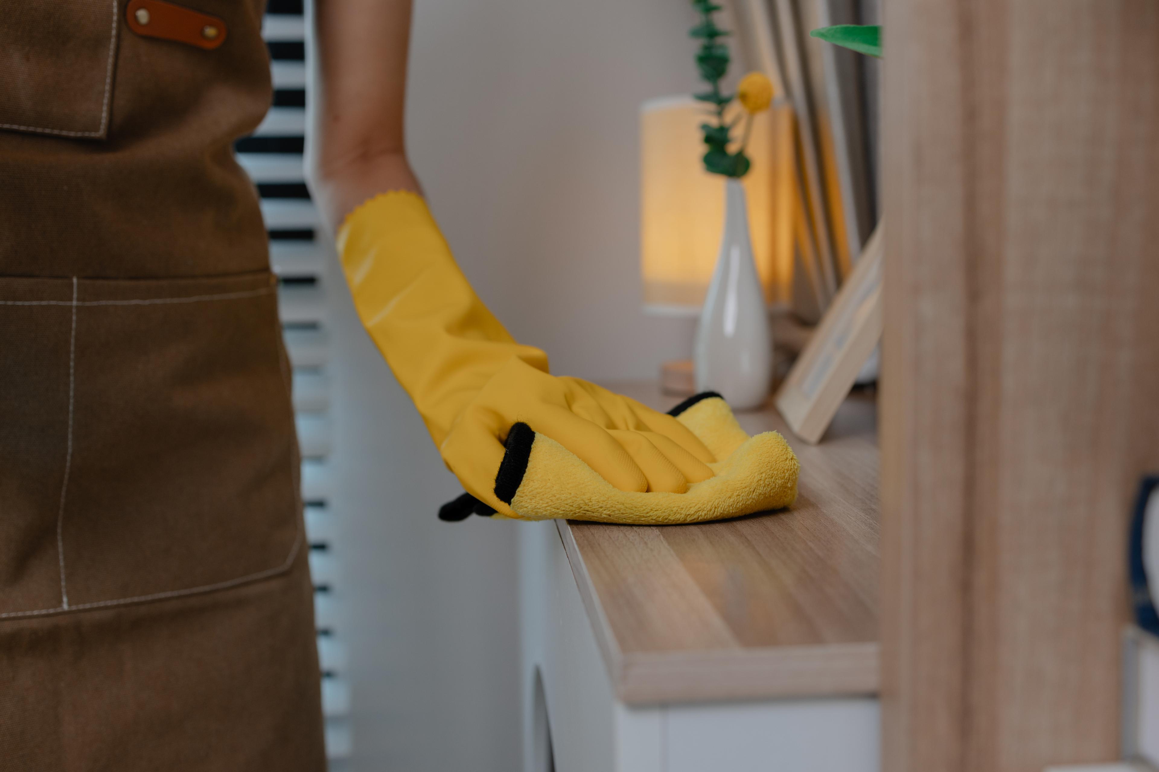Someone cleaning a kitchen table top